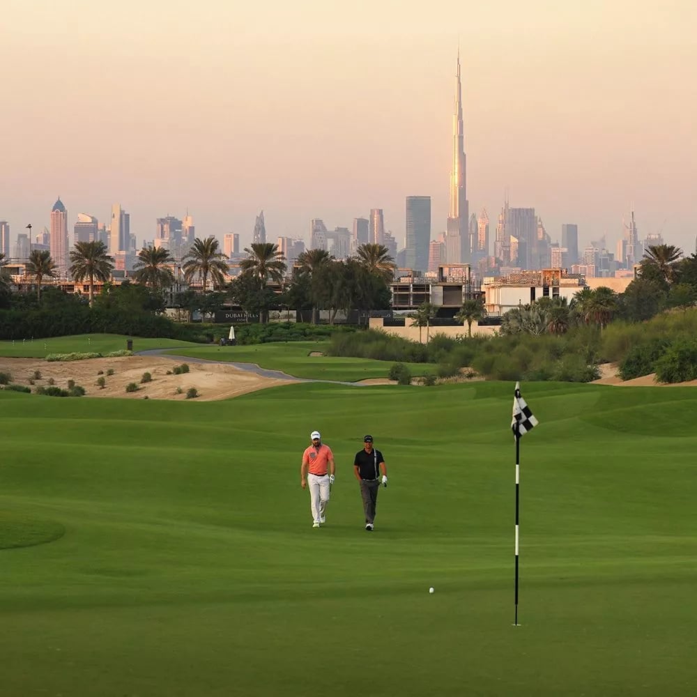 Golfers walking to the flag with Burj Khalifa and Downtown on the skyline
