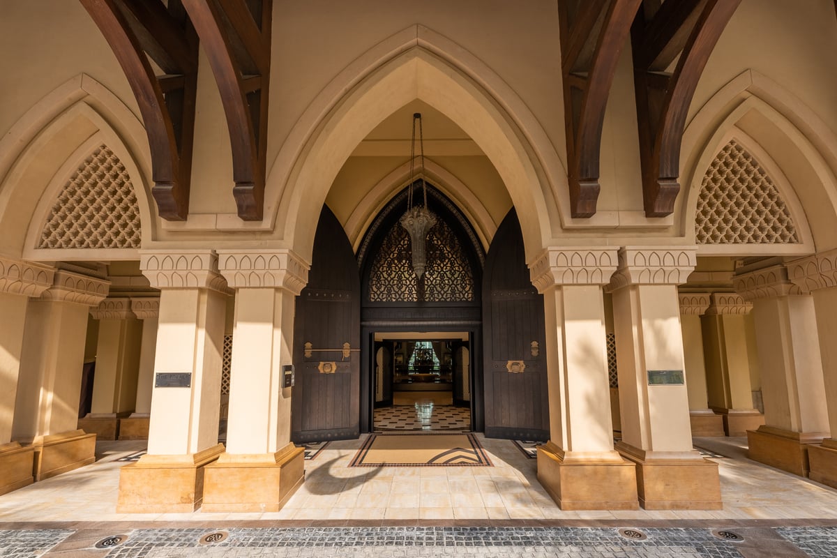 The arched entrance of Palace Downtown, carved lattice above sandstone columns