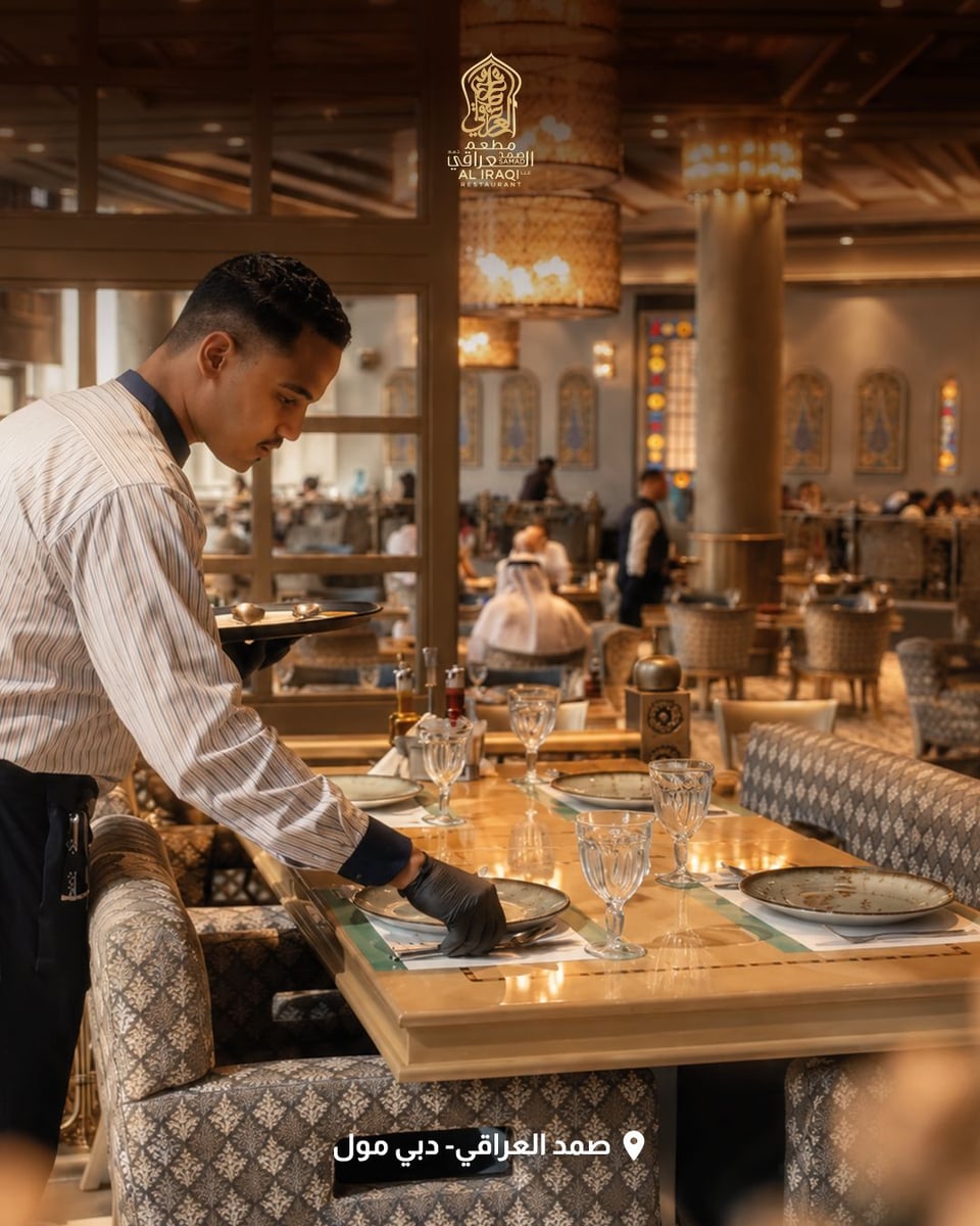A waiter setting a table at Samad Al Iraqi