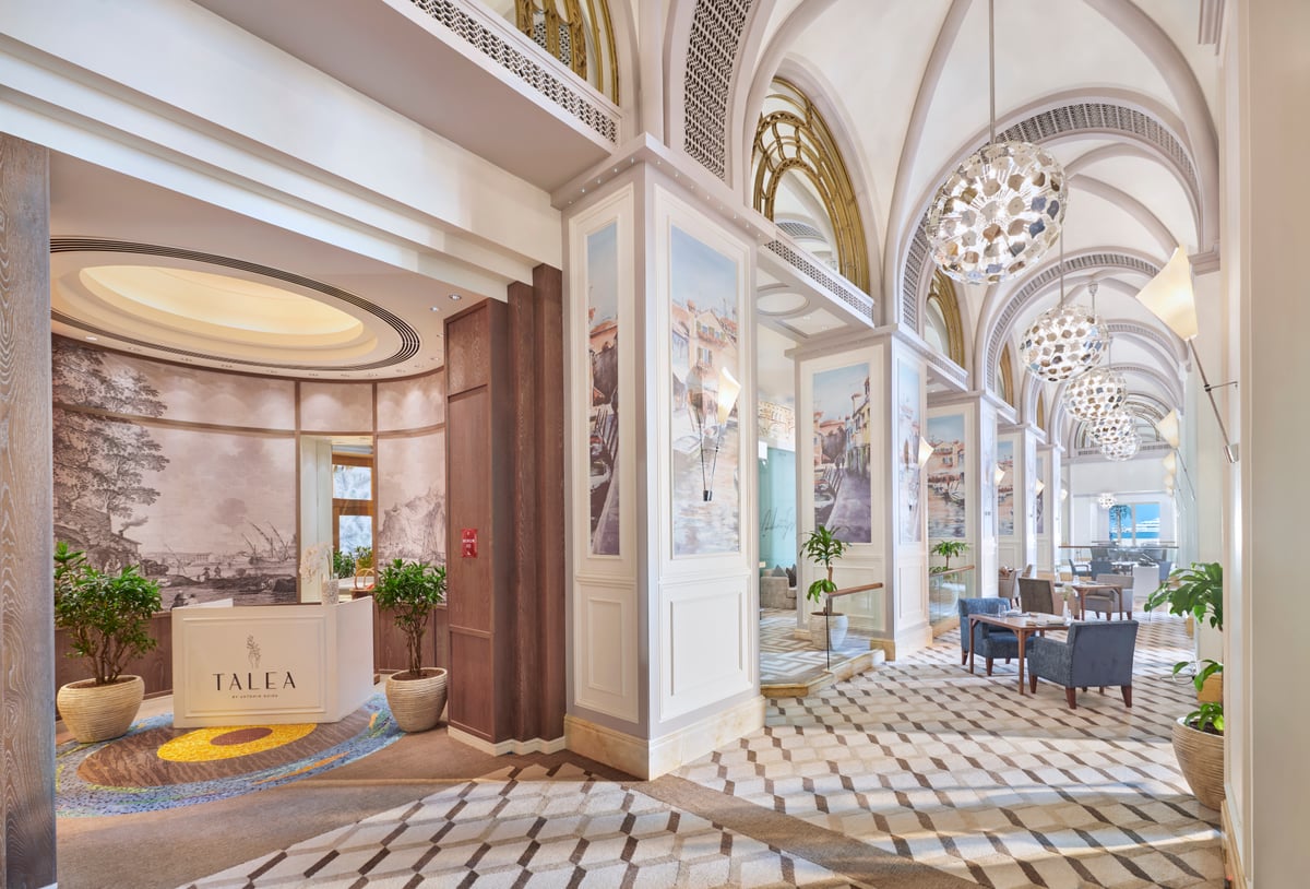 Talea's entrance off a vaulted gallery, a gold-lettered sign before the doorway and patterned marble floors